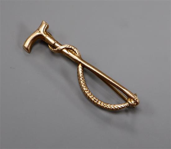 A 9ct. gold riding crop brooch, 37mm.